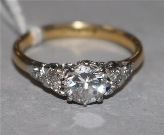 An 18ct gold and platinum, single stone diamond ring with diamond set shoulders, size O.